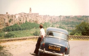 Mark leaning on a car near an Italian town